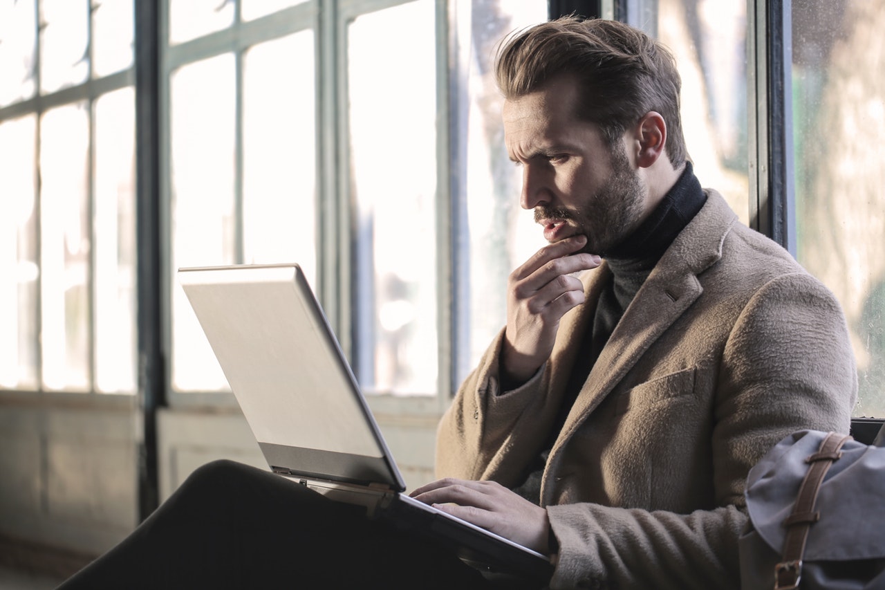  man choosing from functional and chronological resume formats on his laptop