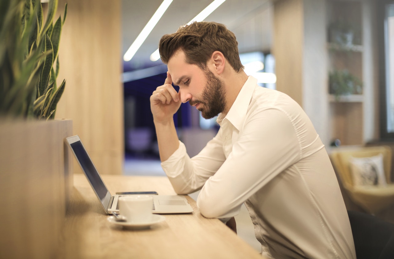 Male job applicant reading a blog about resume writing for dummies in a laptop