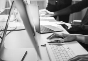 grayscale images of the hands of professional resume writers with laptops