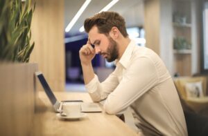 a lonely man looking sadly in a laptop after an interview gone wrong