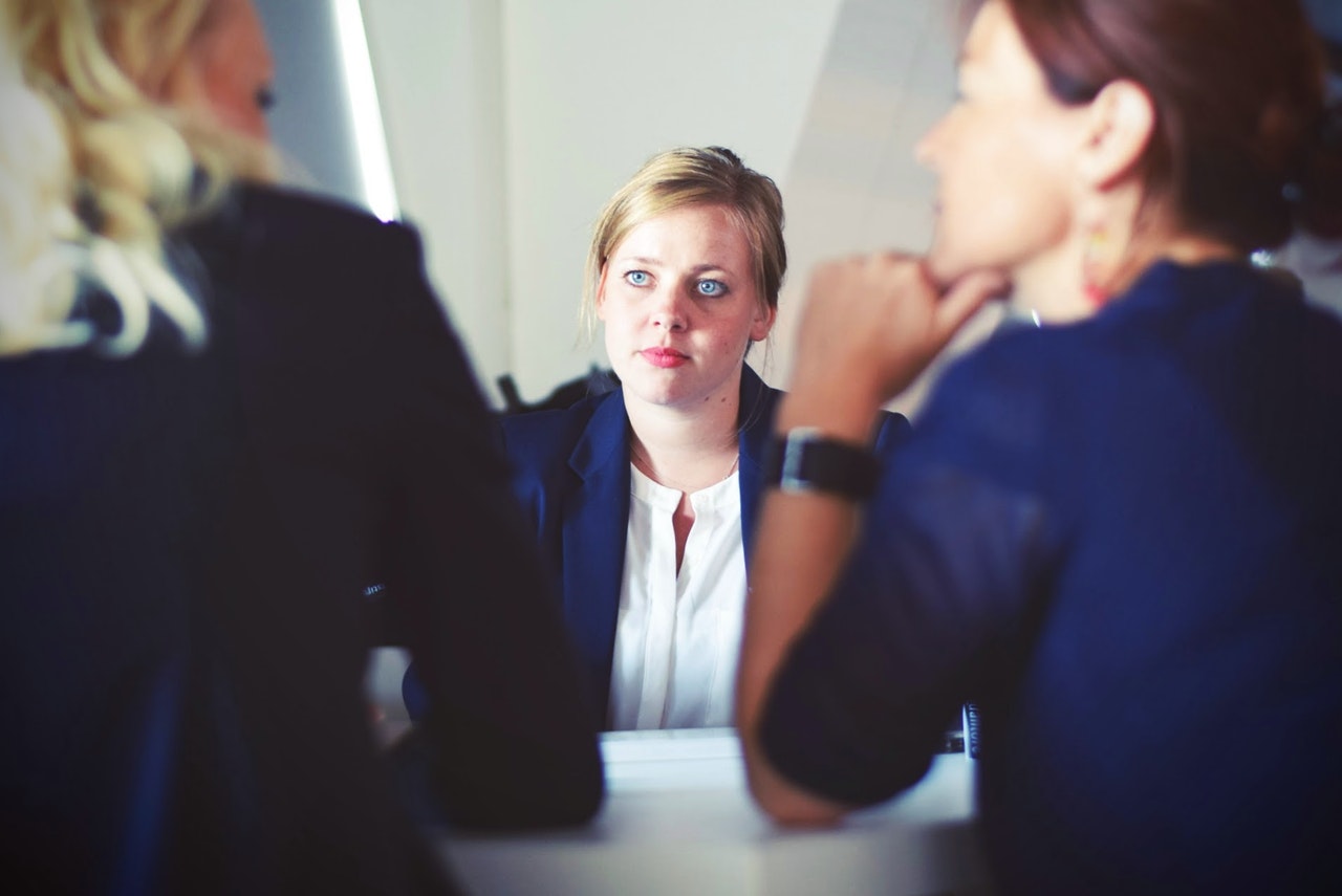 confused woman facing two people after an interview gone wrong