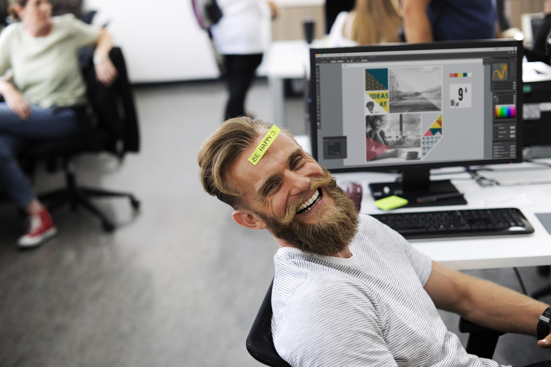 Pros in Working at FAcebook: Perks and Benefits makes a man with a sticky note on his forehead laugh in front of his laptop