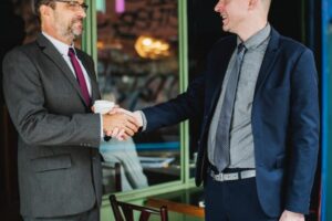 an employer shakes hands with his applicant after a successful salary negotiation