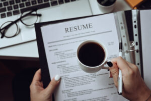 fix my resume while holding coffee cup pen paper both hands