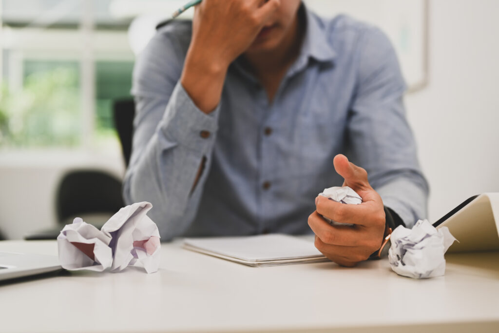 man writing resume for employment gap with crumpled paper