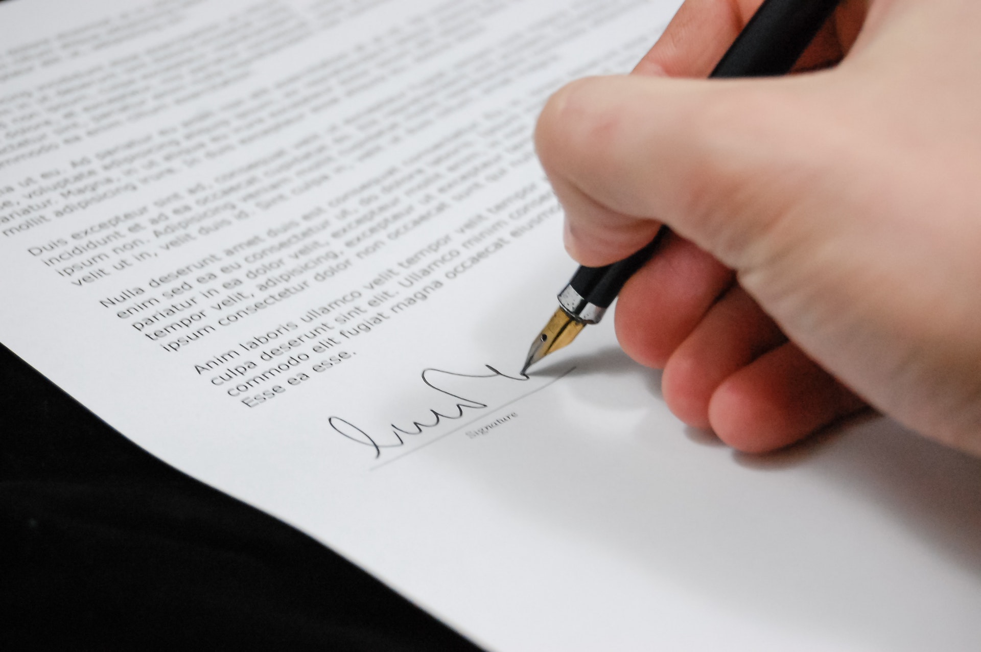 A person affixes his signature on a cover letter