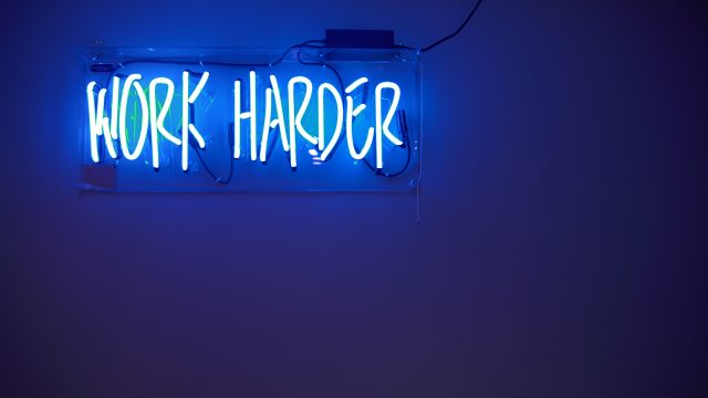 work addiction Neon lights spelling the words Work Harder
