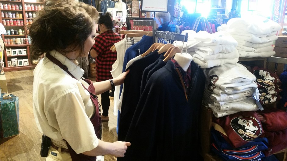 sales clerk sorting clothes for retail sale, a sales associate job description