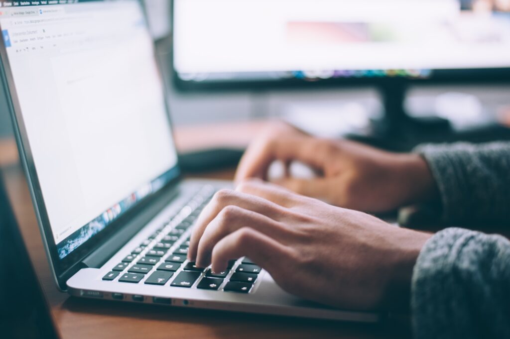 a person writing resume sections using laptop