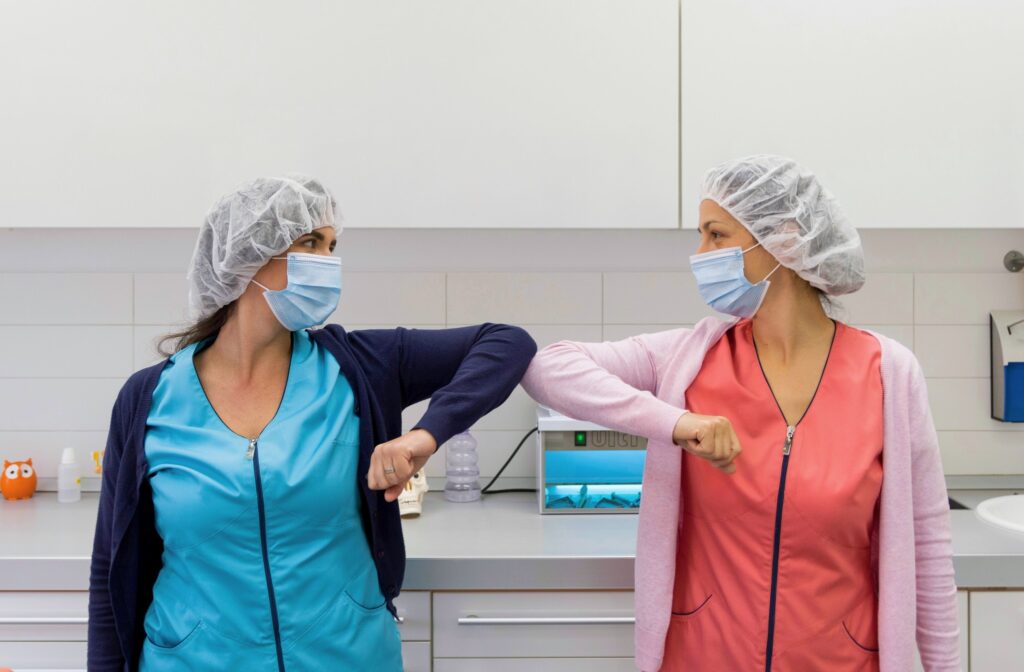 two young workers practicing social distancing as medical professionals, one of recession-proof jobs