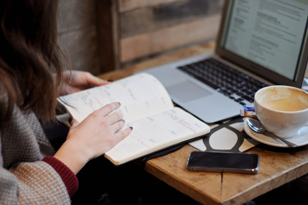 job seeker preparing her resume while reviewing her calendar schedule