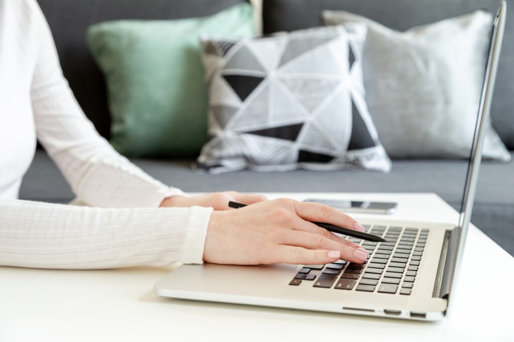 job seeker using her laptop to incorporate action verbs for resume