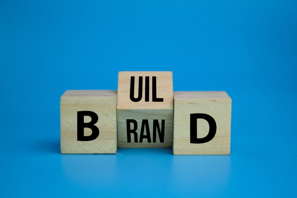 wooden cube with the word Build your brand symbol.